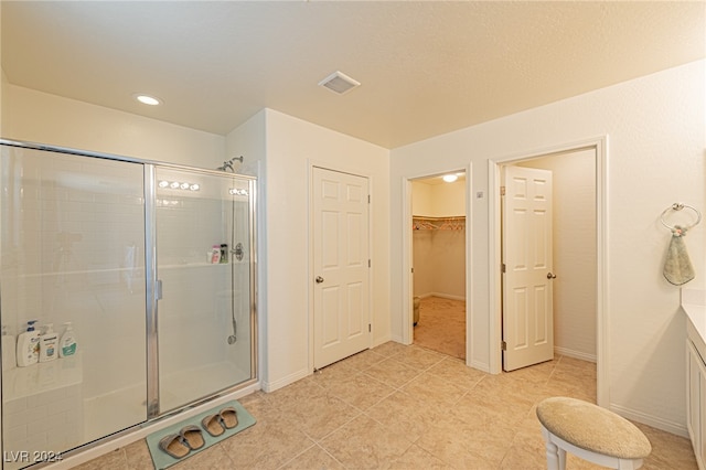 bathroom with vanity, tile patterned floors, and a shower with shower door