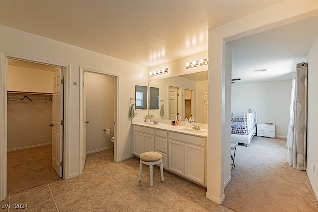 bathroom with vanity, a textured ceiling, and toilet