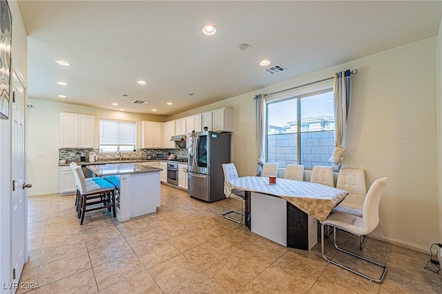 kitchen featuring a breakfast bar area, a center island, stainless steel appliances, and plenty of natural light