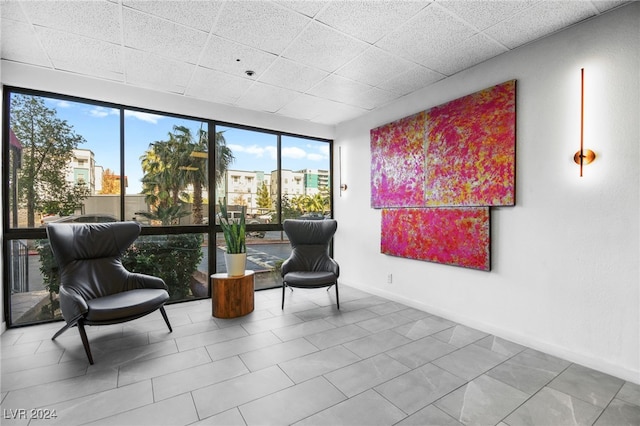 living area featuring a paneled ceiling