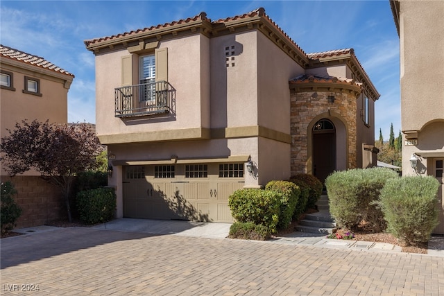 mediterranean / spanish home featuring a balcony and a garage