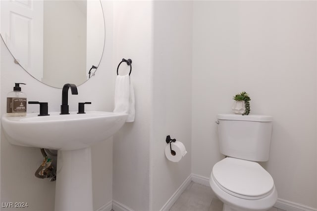 bathroom featuring toilet and tile patterned flooring