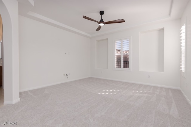 spare room with ceiling fan and light colored carpet