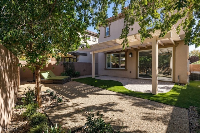 rear view of house with a patio, cooling unit, and a pergola