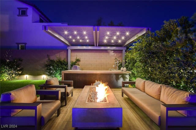 patio at twilight with an outdoor living space with a fire pit