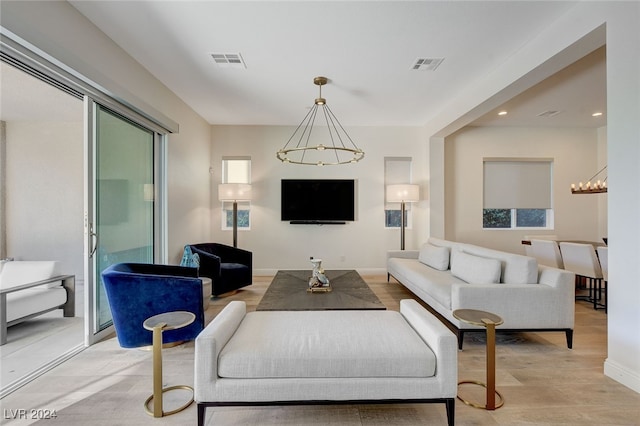 living room featuring light hardwood / wood-style floors and an inviting chandelier