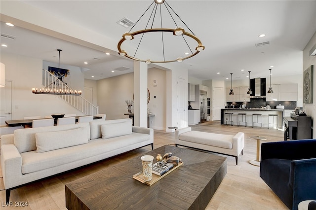 living room with light hardwood / wood-style floors and a chandelier