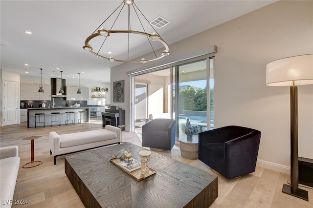 living room with light hardwood / wood-style flooring and an inviting chandelier