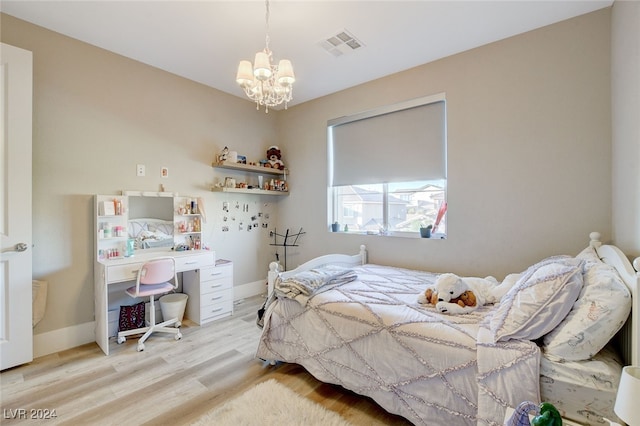 bedroom with a notable chandelier and light wood-type flooring