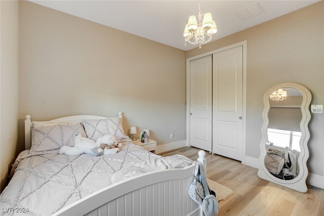 bedroom with a closet, hardwood / wood-style floors, and a chandelier