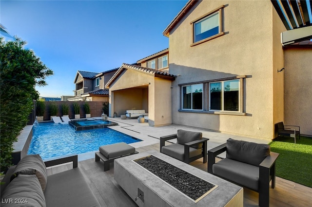 view of pool with an in ground hot tub, a patio area, and an outdoor living space with a fire pit