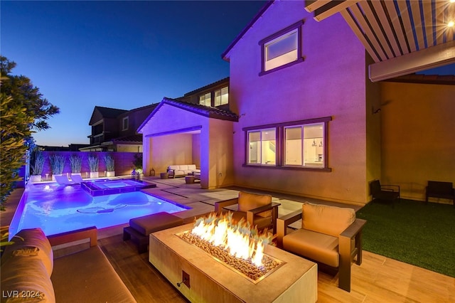 pool at dusk with an in ground hot tub, an outdoor fire pit, and a patio