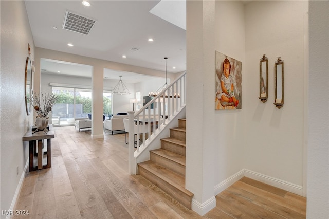 staircase featuring a notable chandelier and hardwood / wood-style flooring