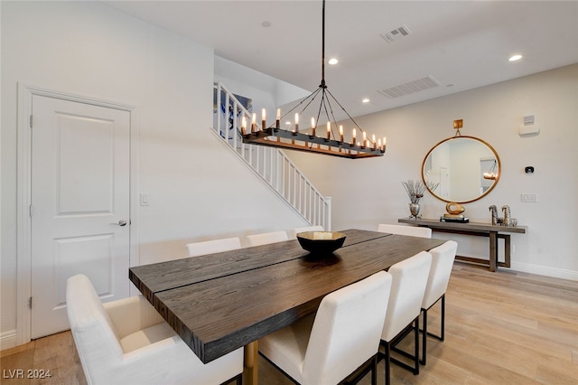 dining room with a notable chandelier and light wood-type flooring