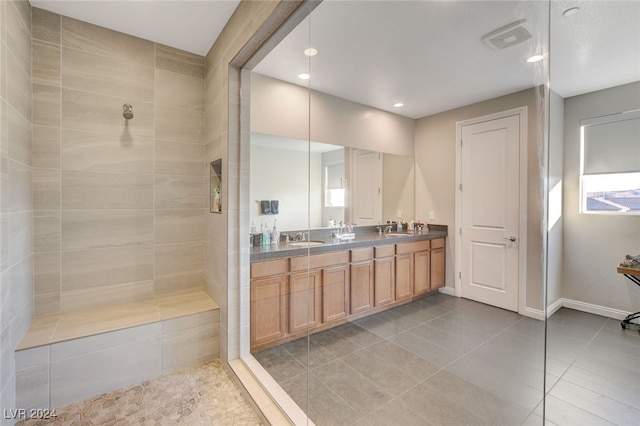 bathroom featuring vanity, plenty of natural light, tiled shower, and tile patterned flooring