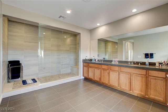 bathroom featuring vanity, a tile shower, and tile patterned flooring