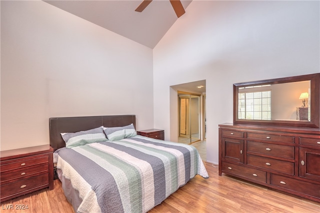 bedroom featuring light hardwood / wood-style flooring, high vaulted ceiling, and ceiling fan