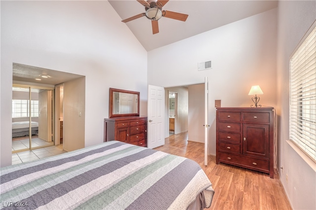 bedroom with high vaulted ceiling, multiple windows, light wood-type flooring, and ceiling fan