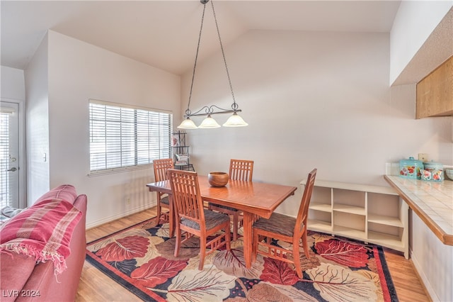 dining area with lofted ceiling and light hardwood / wood-style floors