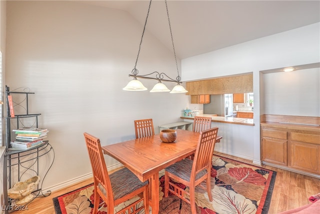 dining room featuring light hardwood / wood-style flooring and high vaulted ceiling