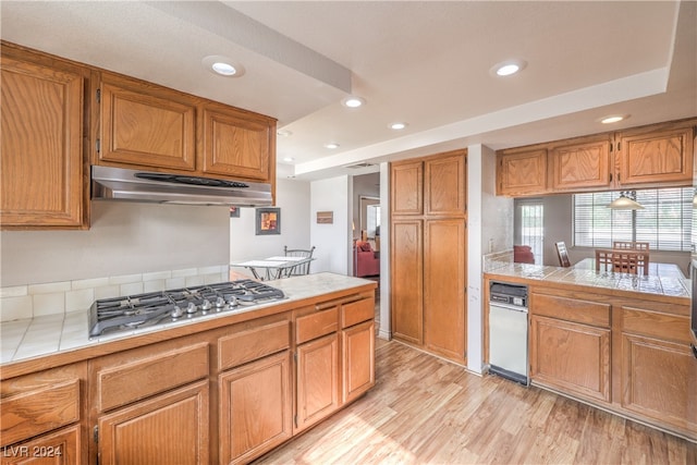 kitchen featuring tile countertops, stainless steel gas stovetop, and light hardwood / wood-style floors