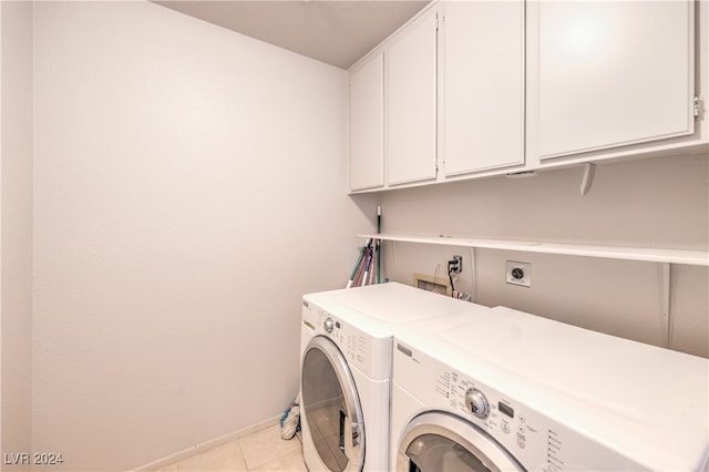 laundry room featuring independent washer and dryer, light tile patterned floors, and cabinets