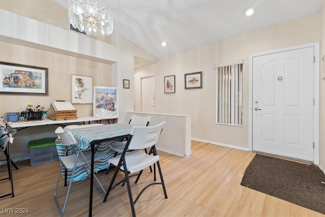 dining area with light hardwood / wood-style floors and vaulted ceiling