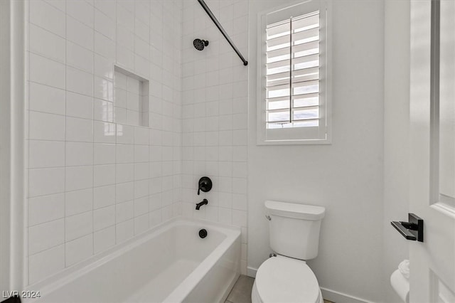 bathroom with tiled shower / bath combo and toilet