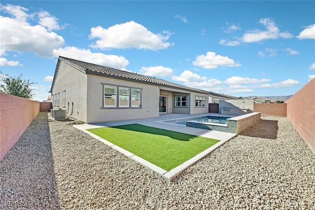 back of property with a patio area, a yard, central AC unit, and a pool with hot tub