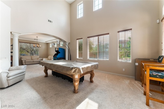 recreation room with light carpet, pool table, a chandelier, a high ceiling, and ornate columns