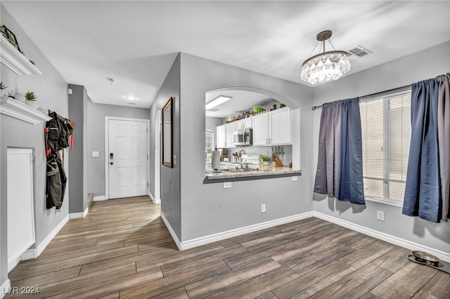 entrance foyer featuring dark hardwood / wood-style floors and a chandelier