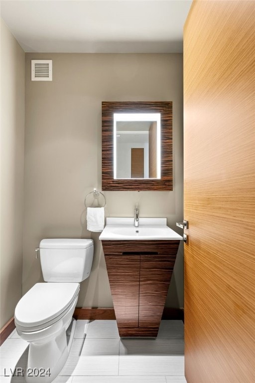 bathroom with vanity, toilet, and tile patterned flooring