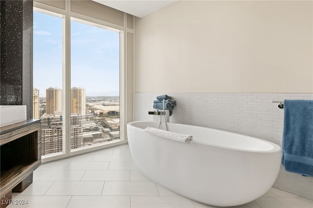 bathroom featuring a tub, tile patterned floors, and tile walls