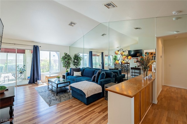 living room featuring vaulted ceiling and light hardwood / wood-style flooring