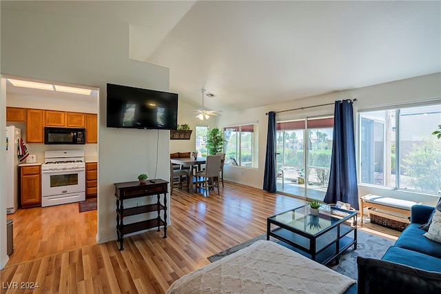 living room featuring light hardwood / wood-style flooring, high vaulted ceiling, and ceiling fan