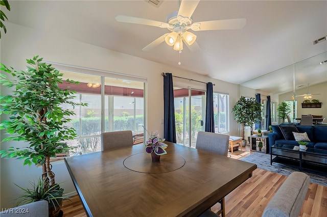 dining area featuring ceiling fan, wood-type flooring, and vaulted ceiling