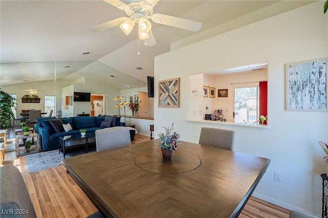 dining room featuring vaulted ceiling, light wood-type flooring, and ceiling fan