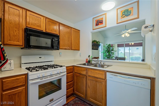 kitchen with white appliances, vaulted ceiling, sink, and ceiling fan