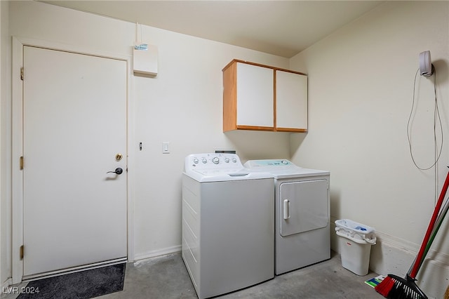 clothes washing area with independent washer and dryer and cabinets