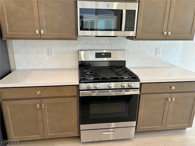 kitchen featuring decorative backsplash, stainless steel appliances, and light hardwood / wood-style flooring