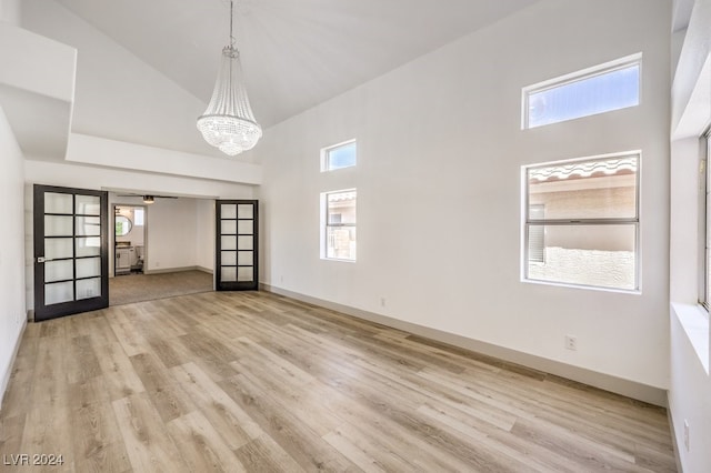 unfurnished room with high vaulted ceiling and light hardwood / wood-style flooring