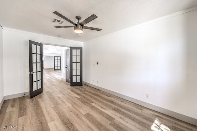 empty room with light hardwood / wood-style floors, french doors, crown molding, and ceiling fan