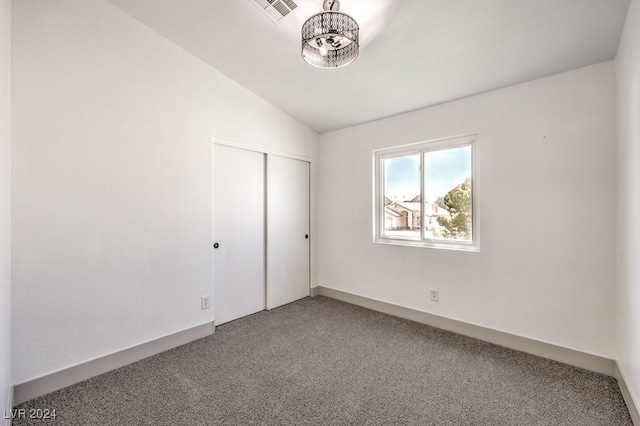 unfurnished bedroom with a closet, carpet flooring, and lofted ceiling