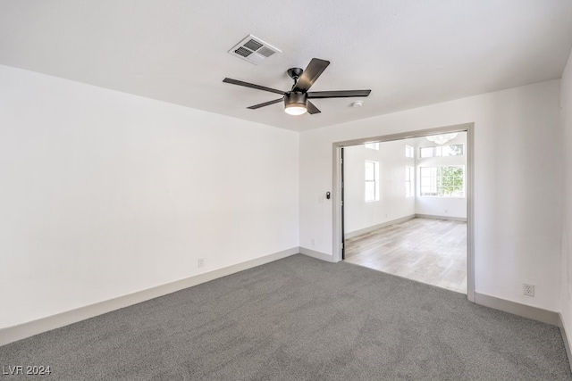 unfurnished room featuring light carpet and ceiling fan