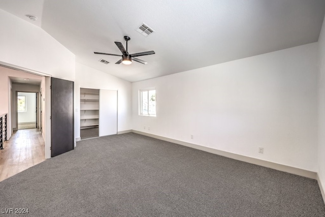 unfurnished bedroom featuring ceiling fan, carpet flooring, and vaulted ceiling