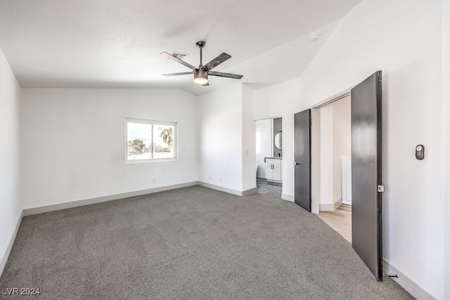 unfurnished bedroom featuring ceiling fan, a textured ceiling, lofted ceiling, and light colored carpet