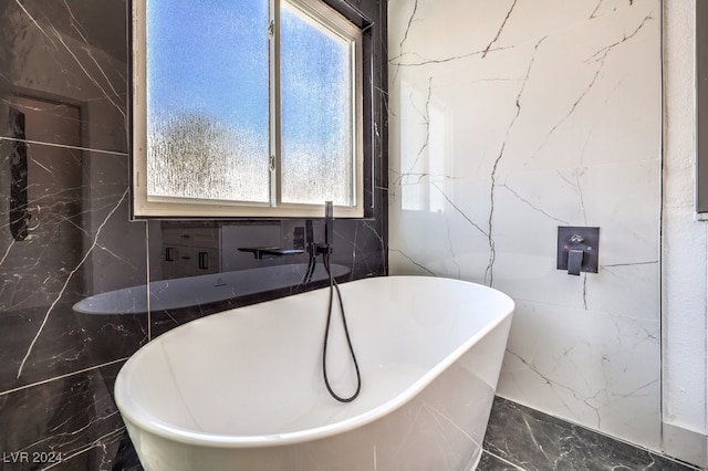 bathroom featuring a tub to relax in and tile walls