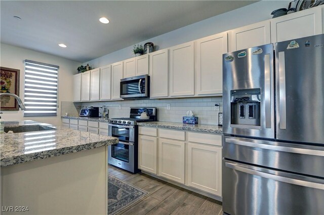 kitchen featuring appliances with stainless steel finishes, white cabinetry, and sink