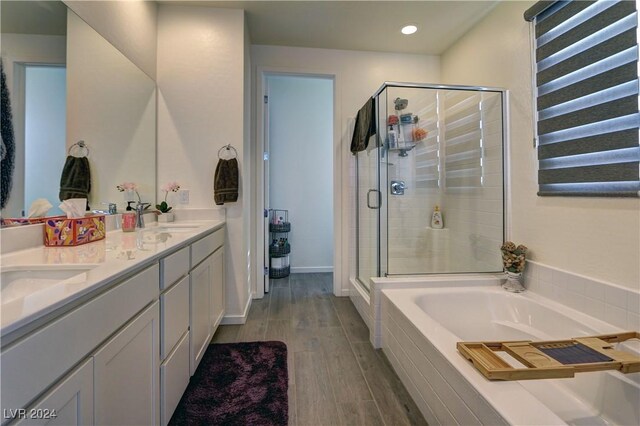 bathroom featuring vanity, wood-type flooring, and shower with separate bathtub