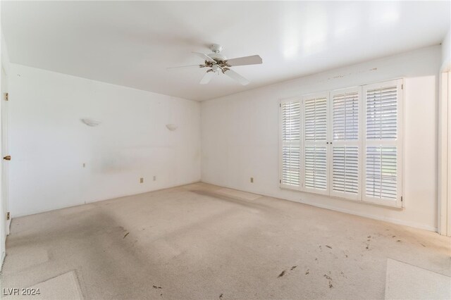 empty room with ceiling fan and light colored carpet